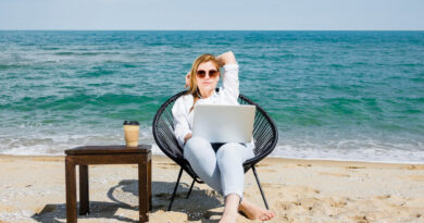 vista frontal da mulher com laptop trabalhando na praia criando conteudo para marketing digital